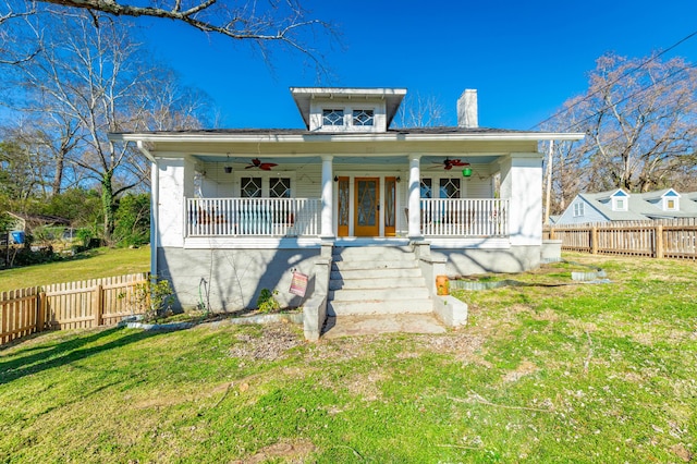 bungalow with covered porch, ceiling fan, and fence