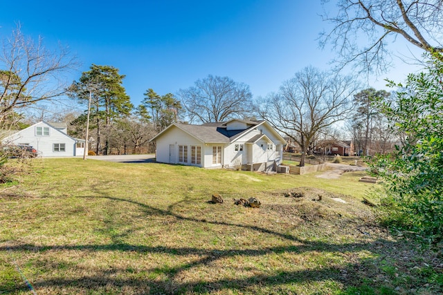 view of side of home with a yard