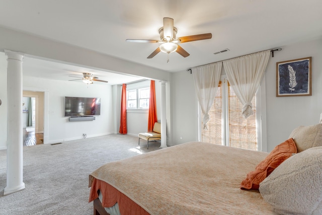 carpeted bedroom with decorative columns, visible vents, and baseboards