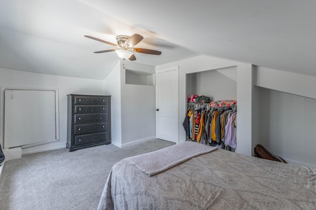 carpeted bedroom with ceiling fan, vaulted ceiling, and a closet