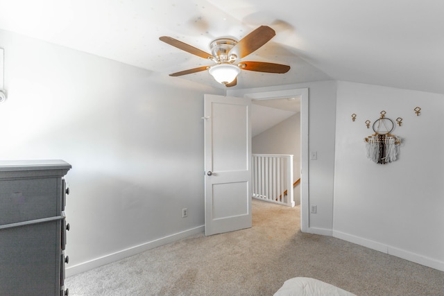 interior space with light carpet, baseboards, and a ceiling fan