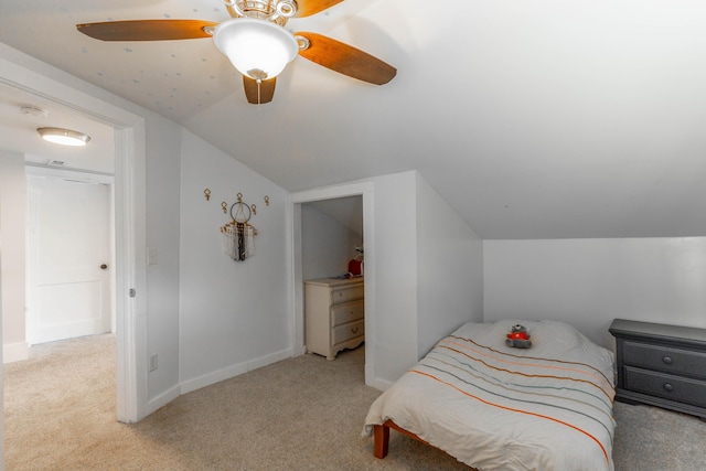 bedroom with light carpet, ceiling fan, baseboards, and vaulted ceiling