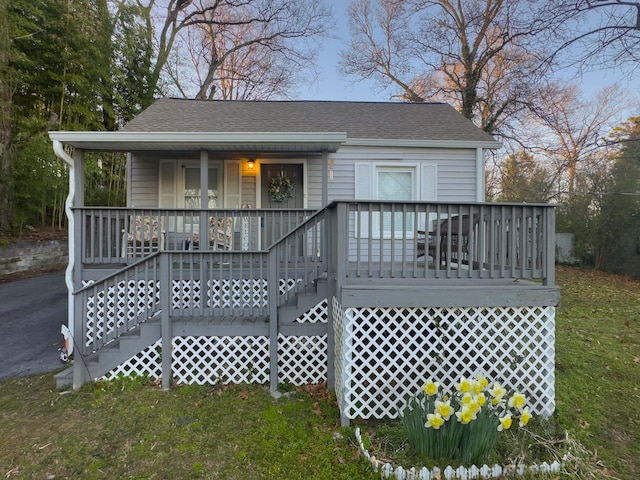 back of property featuring a porch, a chimney, stairs, and roof with shingles