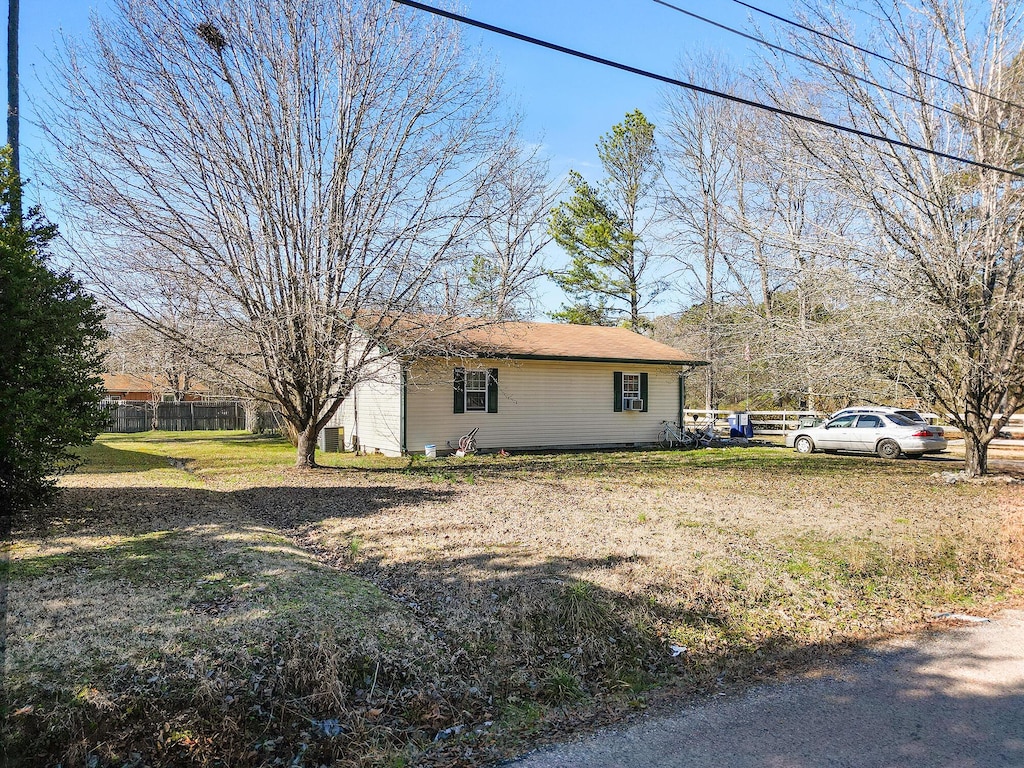 view of side of property with fence and a yard