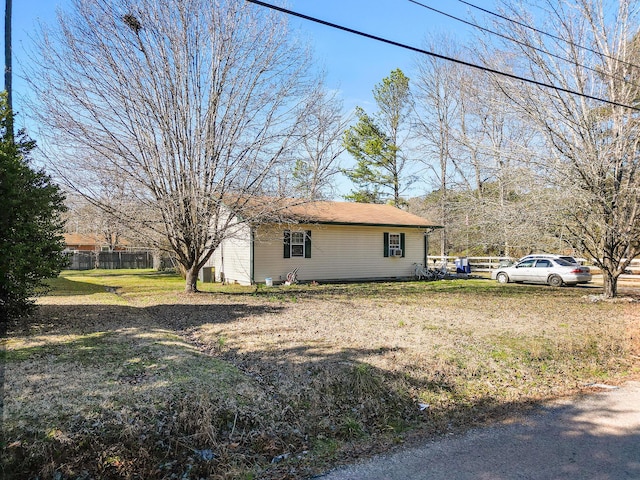 view of side of property with fence and a yard