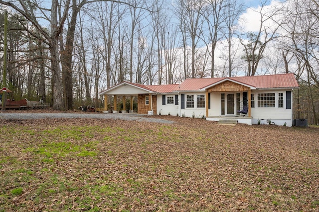 single story home featuring a porch, metal roof, and cooling unit