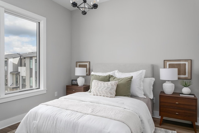 bedroom with a notable chandelier and dark hardwood / wood-style flooring