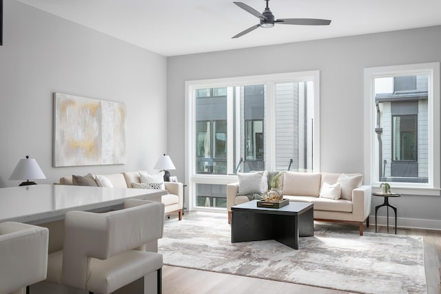 living room with ceiling fan, a healthy amount of sunlight, and light hardwood / wood-style flooring