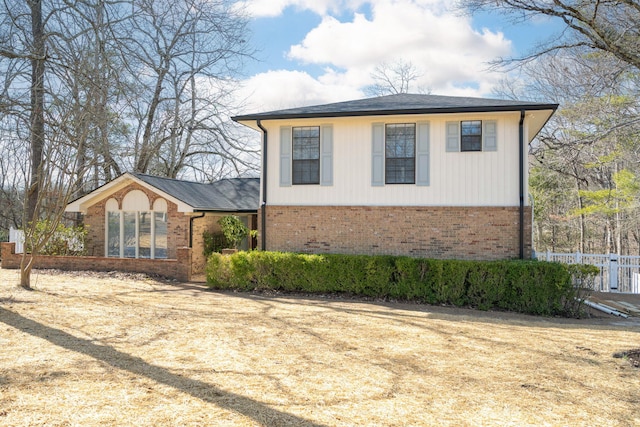 view of property exterior with fence and brick siding