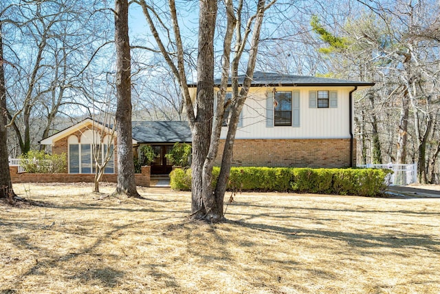 view of front of house with fence and brick siding