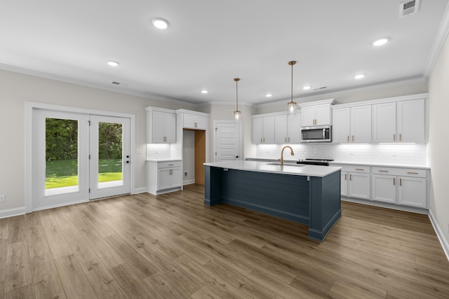 8918 Knolling Lp Unit 32, Ooltewah, TN 37363 - kitchen featuring stainless steel microwave, white cabinets, tasteful backsplash, a sink, and light countertops