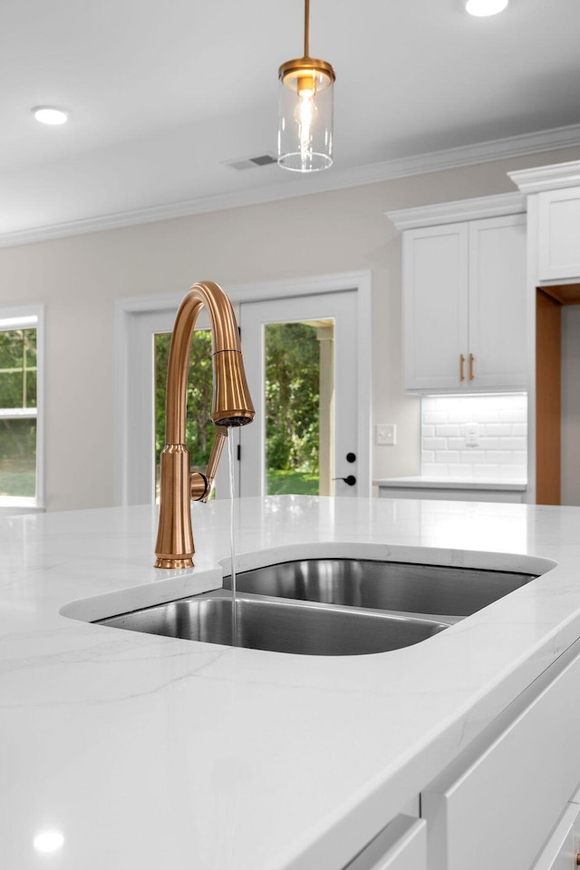 8918 Knolling Lp Unit 32, Ooltewah, TN 37363 - kitchen view of a sink, white cabinets, pendant lighting, ornamental molding, and light stone countertops
