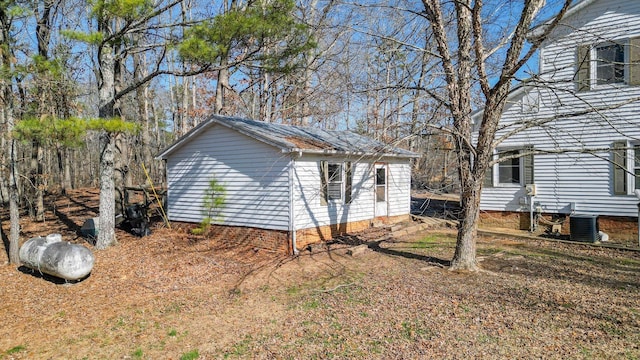 view of property exterior with central air condition unit and a storage unit