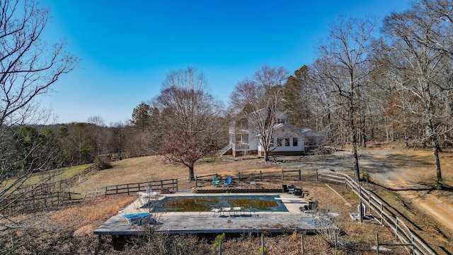 view of yard featuring a rural view and a swimming pool side deck