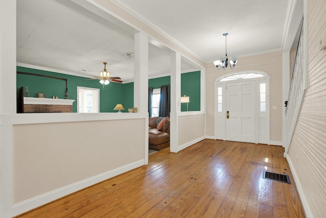 foyer with hardwood / wood-style flooring, ceiling fan with notable chandelier, and ornamental molding