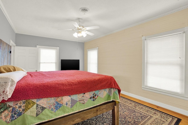 bedroom with crown molding, wood-type flooring, and multiple windows