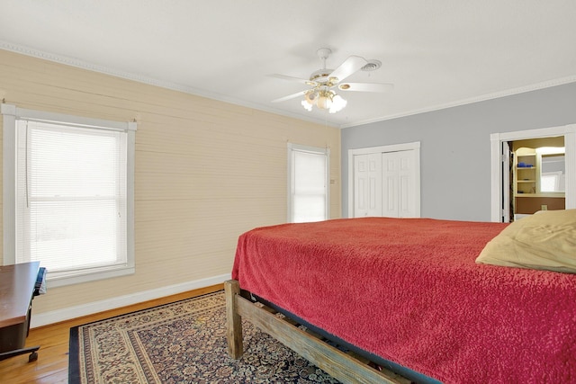 bedroom with crown molding, hardwood / wood-style floors, ceiling fan, and a closet