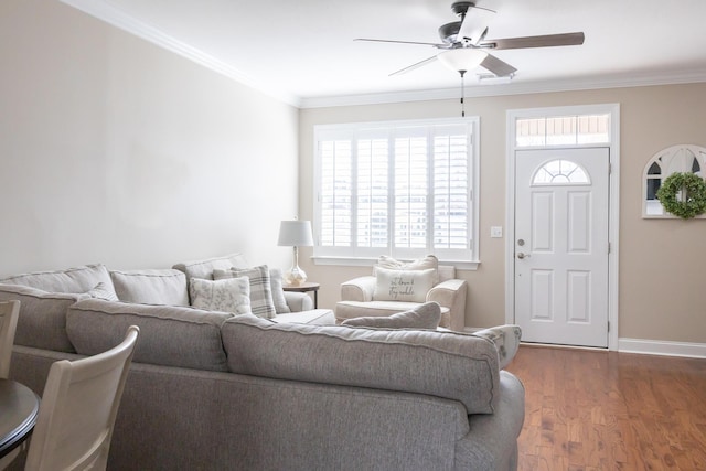 living room with a ceiling fan, crown molding, baseboards, and wood finished floors