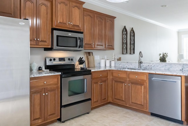 kitchen featuring light stone counters, appliances with stainless steel finishes, brown cabinets, ornamental molding, and a sink