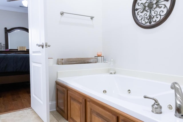 bathroom featuring tile patterned flooring, ensuite bath, a tub with jets, and crown molding