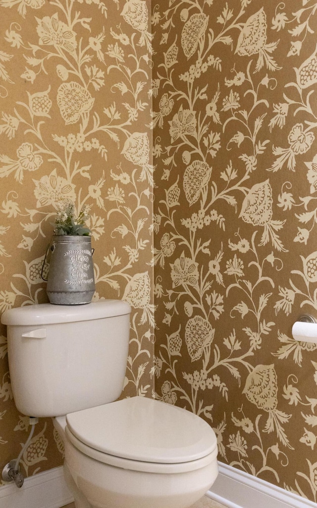 bathroom featuring baseboards, toilet, and wallpapered walls