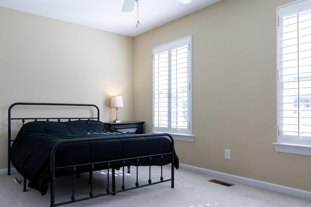 carpeted bedroom with baseboards, multiple windows, and visible vents