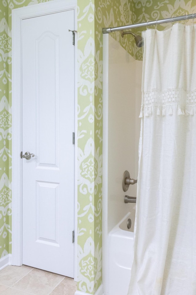 bathroom with wallpapered walls, baseboards, shower / tub combo with curtain, and tile patterned floors