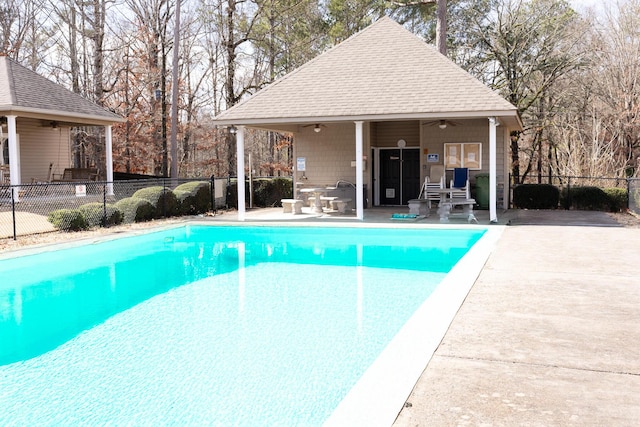 community pool featuring a fenced backyard, ceiling fan, and a patio