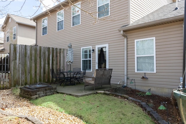 back of property with a patio area, a shingled roof, fence, and a yard