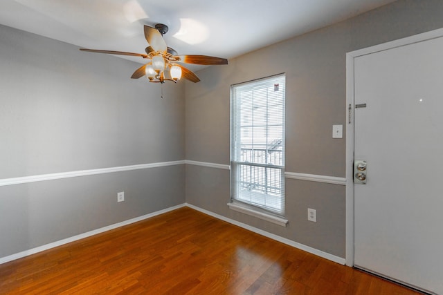 unfurnished room featuring a ceiling fan, baseboards, and wood finished floors