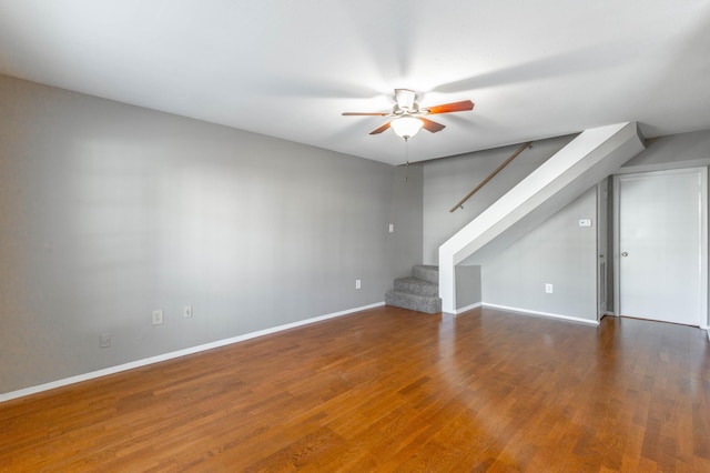 additional living space with ceiling fan, stairway, wood finished floors, and baseboards