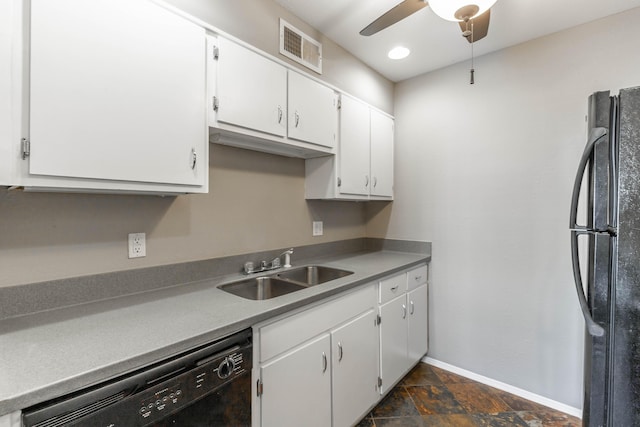 kitchen with black appliances, a sink, white cabinetry, and stone finish flooring