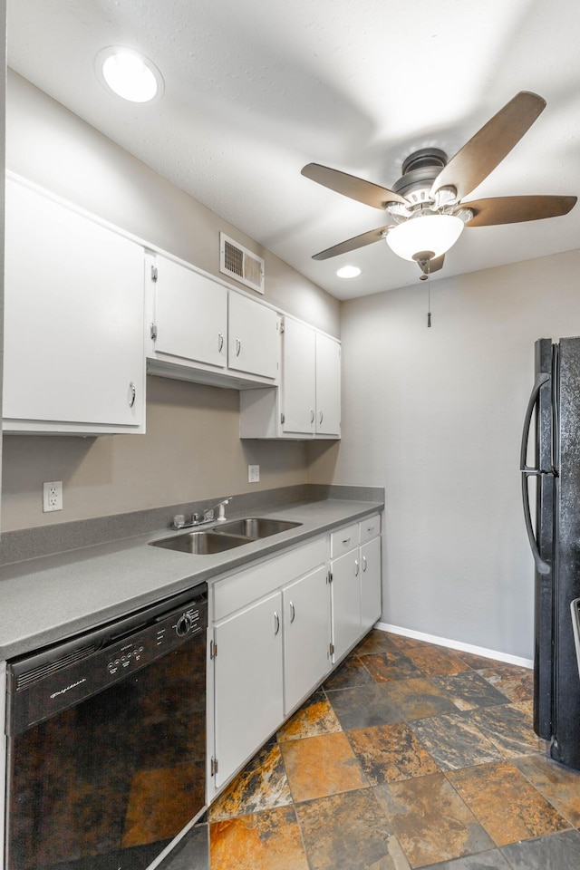 kitchen featuring visible vents, stone finish flooring, black appliances, white cabinetry, and a sink