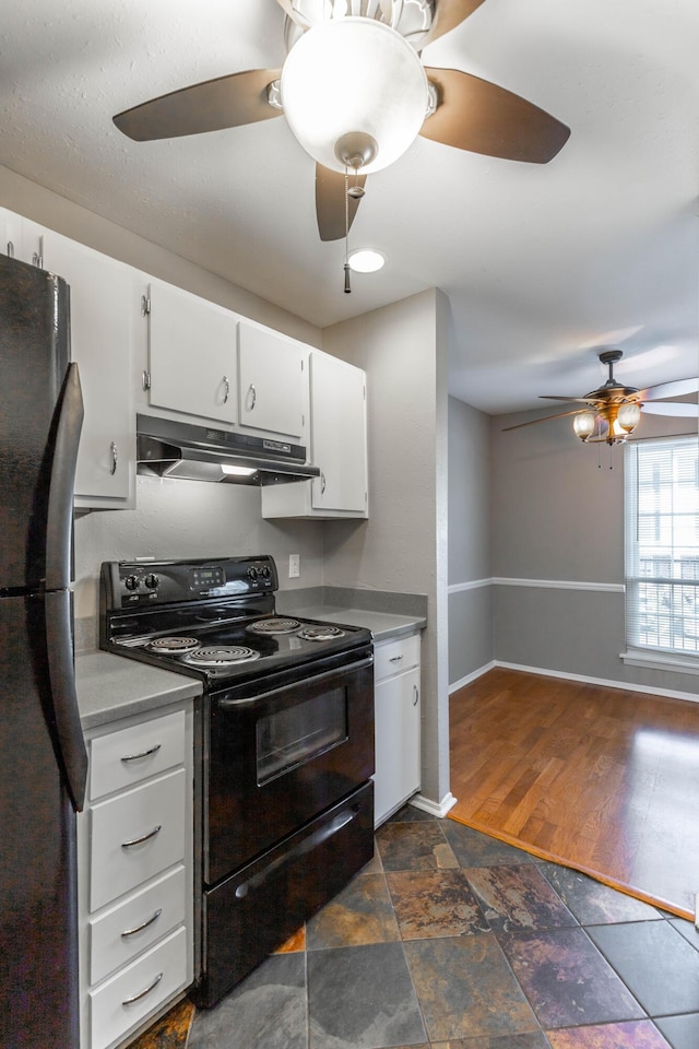 kitchen with baseboards, white cabinets, stone finish flooring, under cabinet range hood, and black appliances