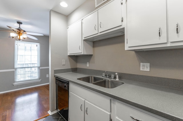 kitchen with black dishwasher, dark countertops, white cabinets, a sink, and ceiling fan