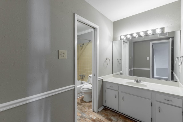 bathroom with a textured wall, shower / bathing tub combination, vanity, and toilet