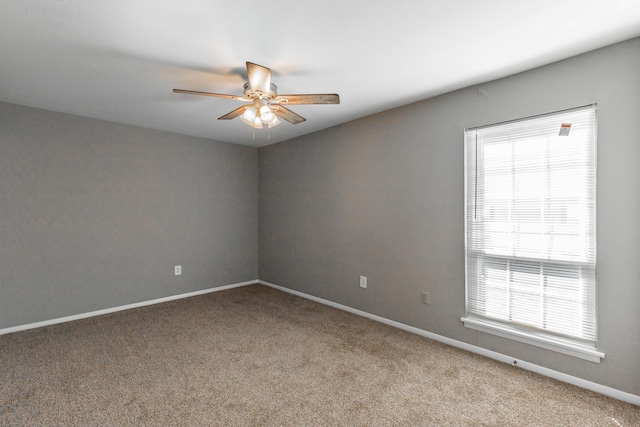 unfurnished room with light colored carpet, ceiling fan, and baseboards