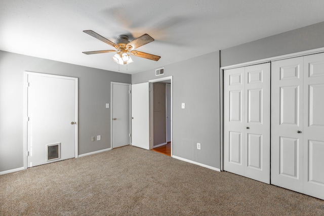 unfurnished bedroom with ceiling fan, visible vents, baseboards, a closet, and dark colored carpet