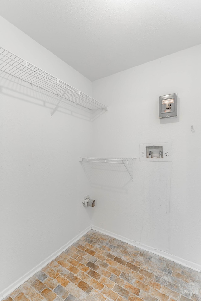 laundry area with brick floor, washer hookup, laundry area, and baseboards