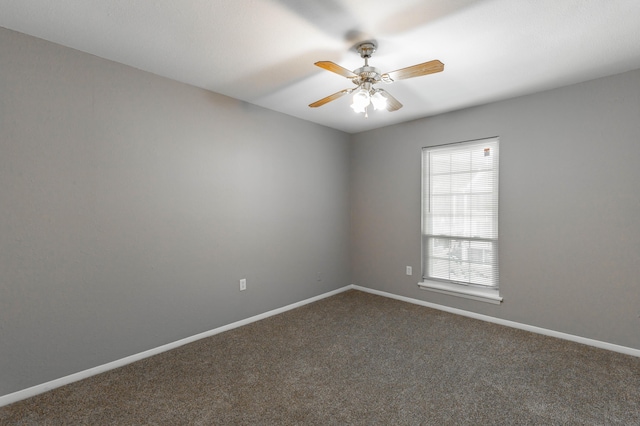 carpeted spare room featuring ceiling fan and baseboards