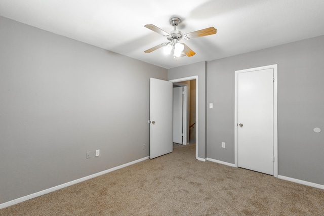 unfurnished bedroom featuring ceiling fan, baseboards, and light colored carpet