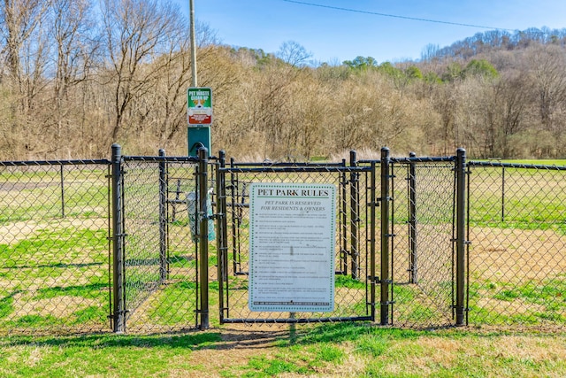 view of gate featuring fence and a lawn