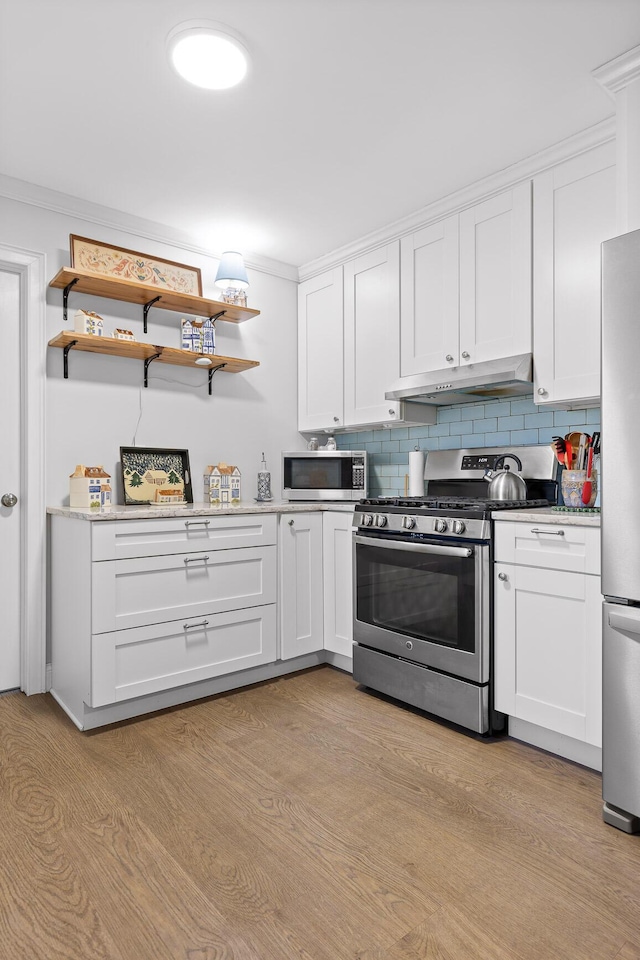 kitchen with stainless steel appliances, light wood-type flooring, backsplash, and under cabinet range hood