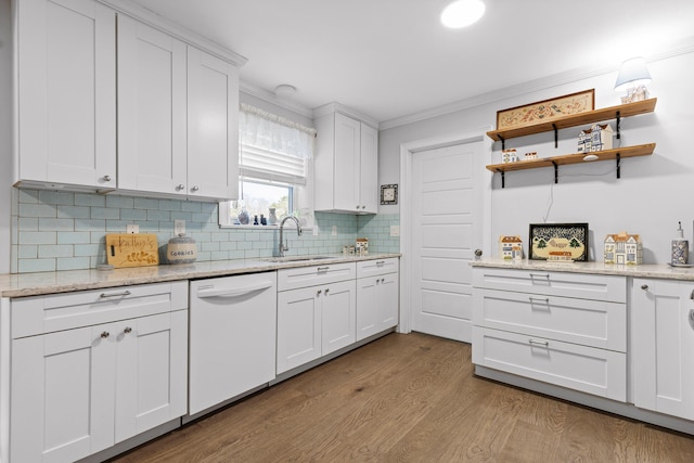 kitchen featuring dishwasher, wood finished floors, crown molding, white cabinetry, and a sink