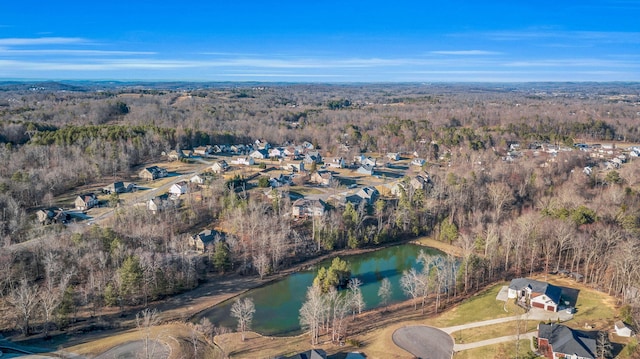 birds eye view of property featuring a water view and a view of trees