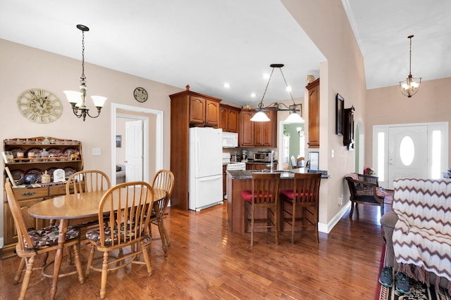 dining room with a notable chandelier, baseboards, and wood finished floors