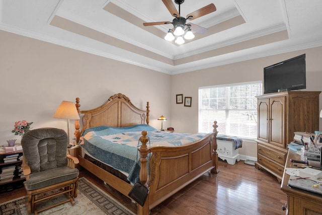 bedroom featuring a tray ceiling, wood-type flooring, and crown molding