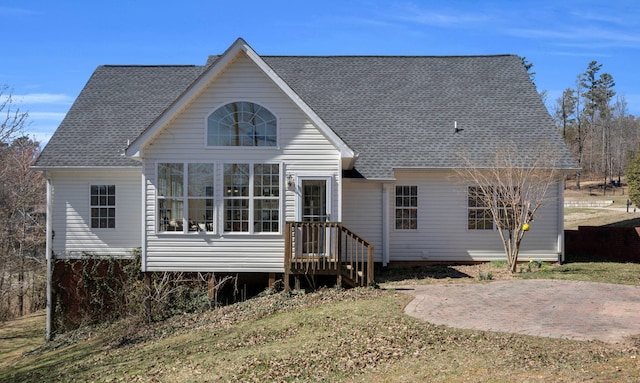 back of property with a patio area and roof with shingles