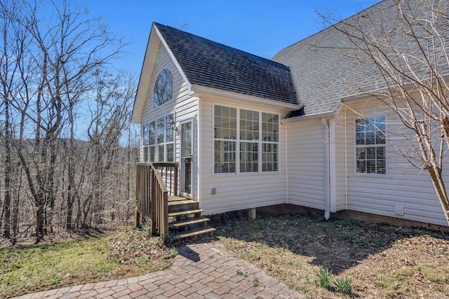 back of house with a shingled roof