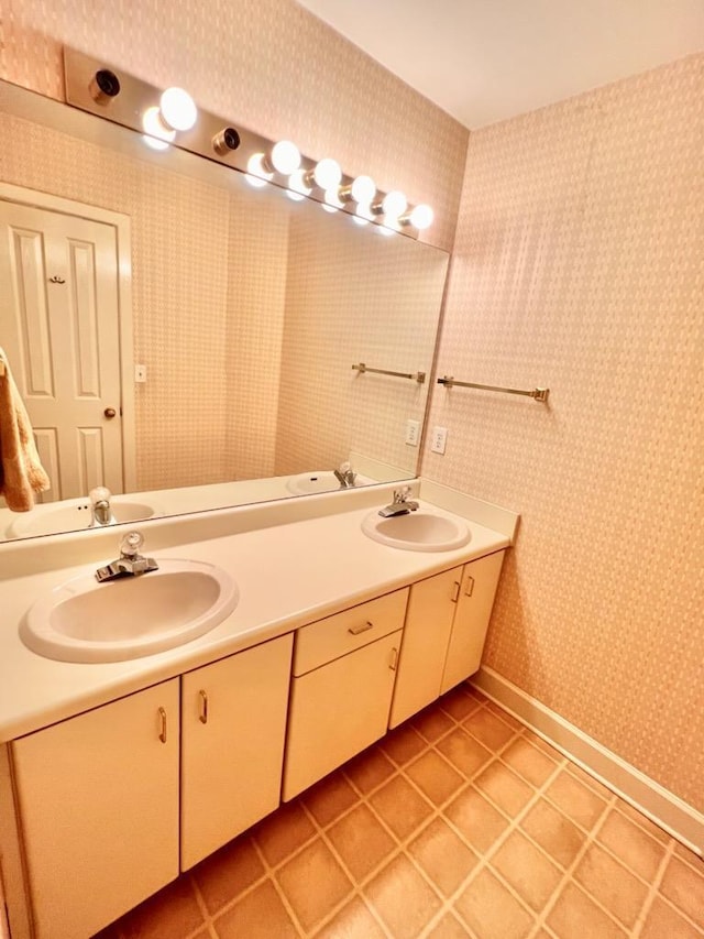 bathroom featuring tile patterned floors, a sink, and wallpapered walls